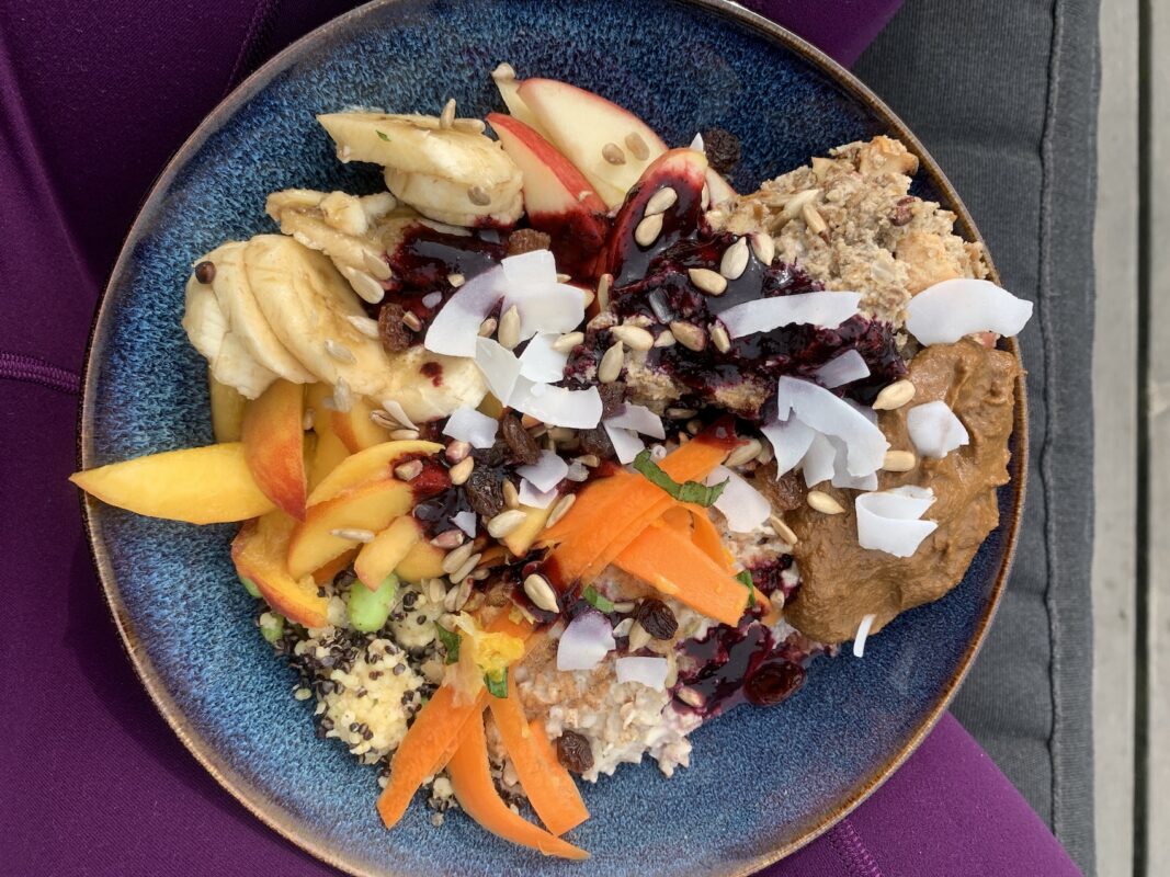 Colorful vegan Buddha bowl with fresh vegetables, grains, and toppings.